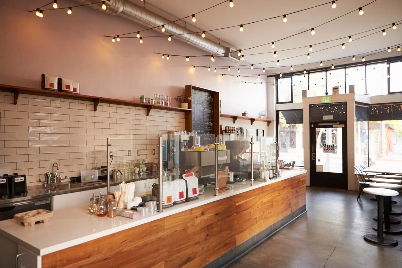 An empty café counter before opening, lit by string lights