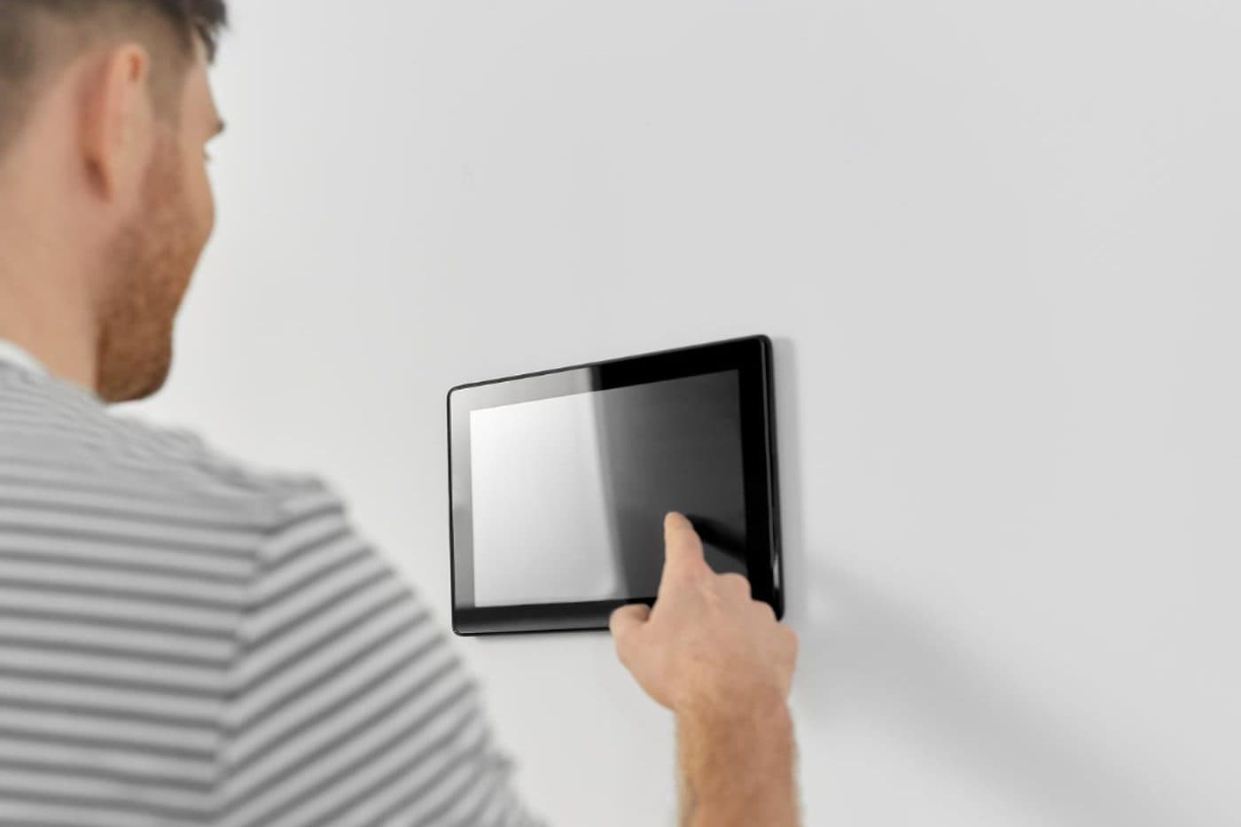 A team member tapping a tablet mounted on the wall by the door
